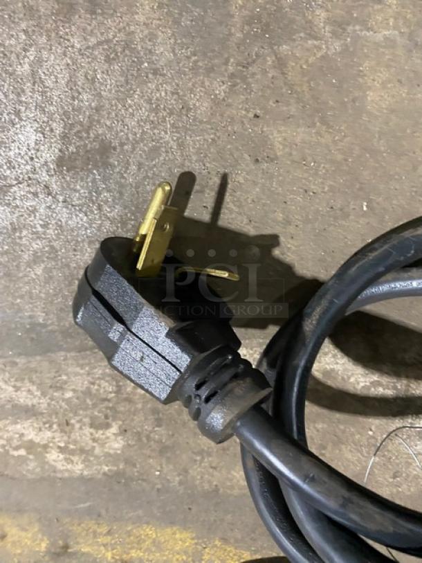 Black electric plug of MerryChef Eikon E2S high-speed cook oven, 208/240V, 1 phase, shown on a concrete surface.