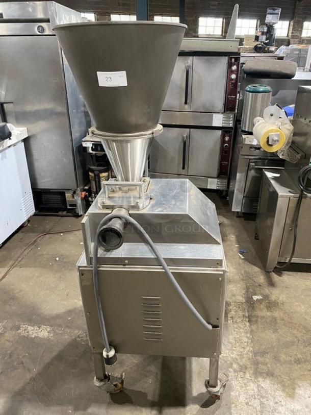 Commercial stainless steel electric sausage meat vacuum stuffer on casters. Features include hopper, nozzle, and hose. Visible label "23".