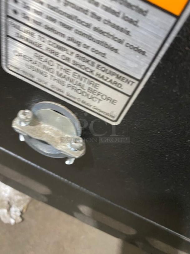 Close-up of a label and fixture on a Bunn ICBTWINSH coffee brewer, featuring safety instructions and Energy Star certification details.