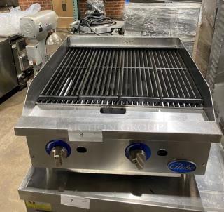 Globe commercial stainless steel natural gas countertop char broiler, serial number 1715042736, featuring control knobs, on sturdy legs.