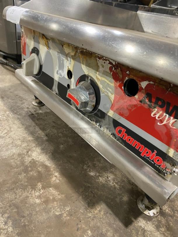 APW Wyott Champion Cook Series stainless steel griddle with back and side splash, natural gas powered, on legs.