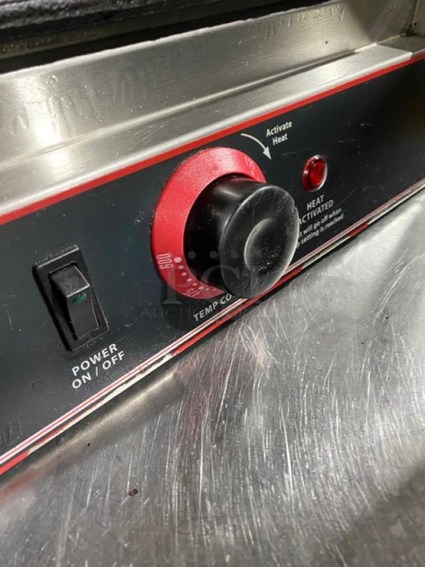 Winco Model EPG1 stainless steel panini grill, featuring grooved grates and temperature control, in used condition. 120V power.