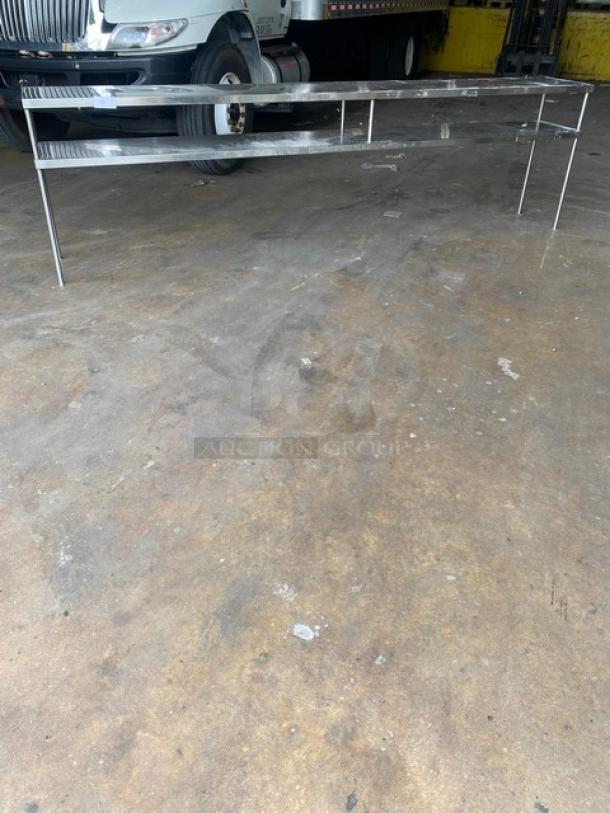 All stainless steel heavy-duty commercial double overhead work shelf, 10 feet long, in excellent condition, ideal for kitchens.