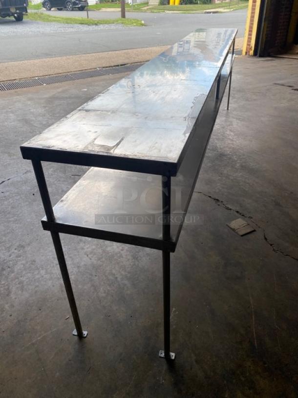 All stainless steel commercial double overhead work shelf, 10 feet long, heavy duty construction, excellent condition.