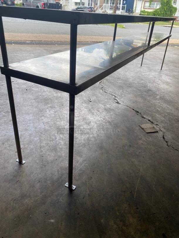 All stainless steel heavy-duty commercial double overhead work shelf, 10 feet long, shown in good condition.
