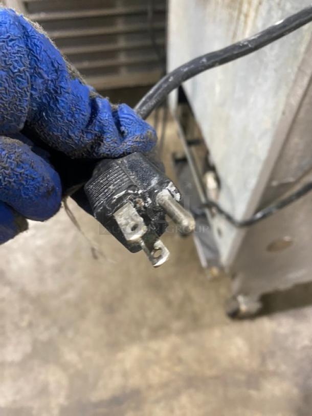Close-up of a power plug for a Pitco Soltice Series natural gas commercial deep fryer. Plug is black and slightly worn.
