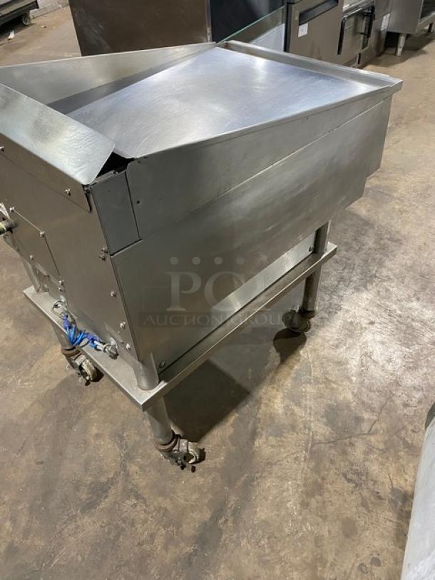 Keating stainless steel natural gas countertop griddle with polished top, thermostatic controls, back and side splash, on casters.