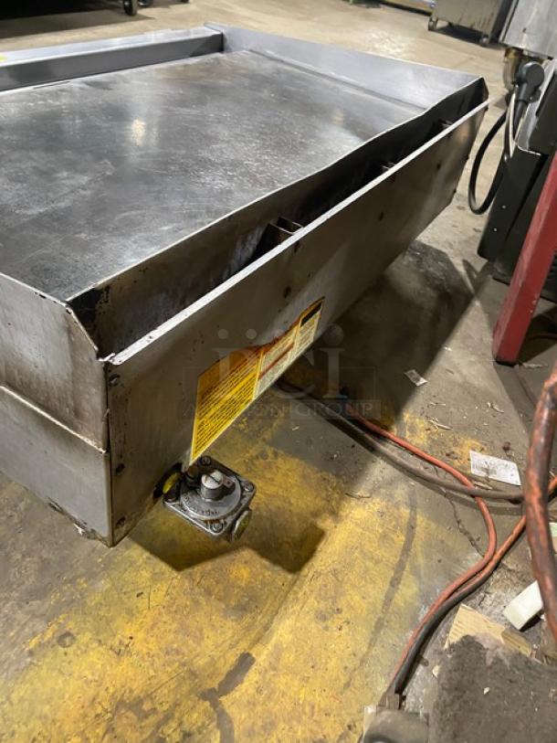 Wolf Regency stainless steel commercial countertop flat top griddle in used condition. Visible control knobs and safety label.