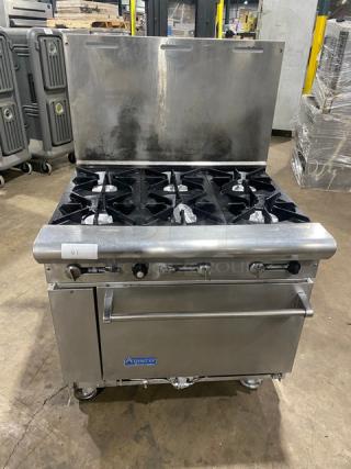 American Range stainless steel 6-burner range/oven combo with backsplash, on casters. Natural gas powered, commercial grade.