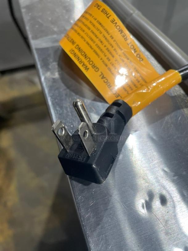 Excellence Industries HFF8HC ice cream dipping cabinet power plug with attached orange warning tag, indicating 115V usage.