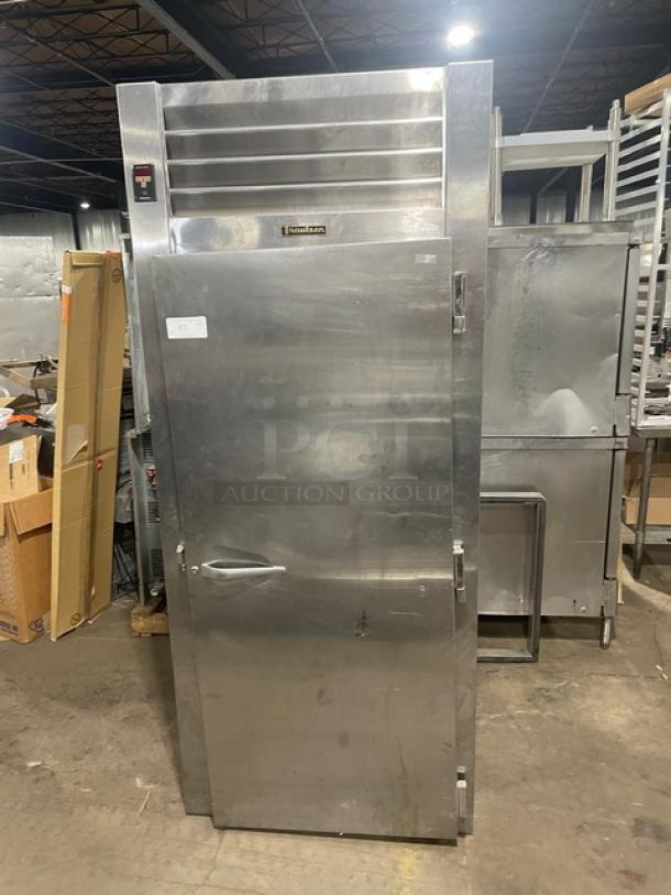 Traulsen stainless steel roll-in refrigerator, model ARI134LUTFHS. Single door, solid construction, visible label, industrial setting.