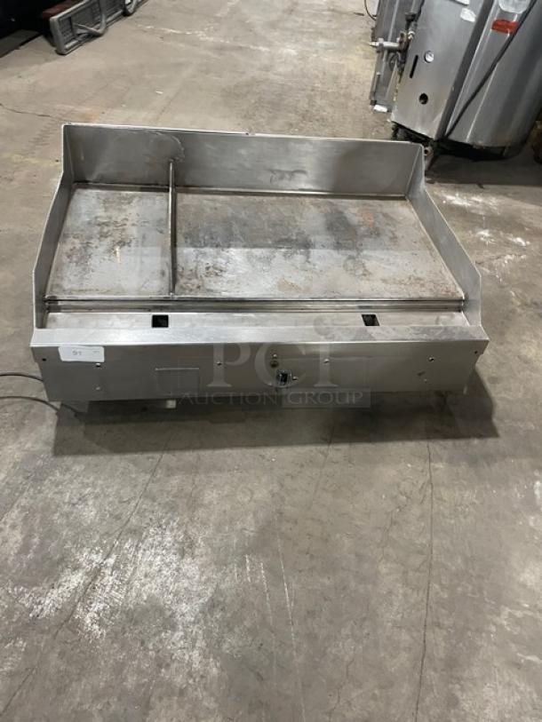 Woodstone stainless steel natural gas countertop grill with split top, backsplash, and legs. Used condition, ideal for commercial use.