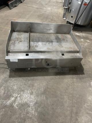 Woodstone stainless steel natural gas countertop grill with split top, backsplash, and legs. Used condition, ideal for commercial use.