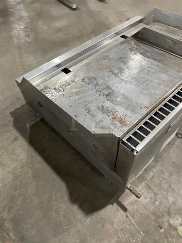 Woodstone stainless steel natural gas countertop split top flat grill with backsplash on legs. Used condition, visible wear.