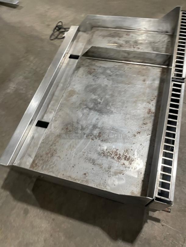Woodstone stainless steel natural gas split top flat grill with backsplash, counter top model on legs, visible wear.