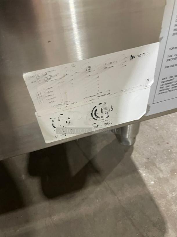 Sierra stainless steel natural gas four-burner range/oven combo with backsplash and overhead salamander shelf. Visible worn label.