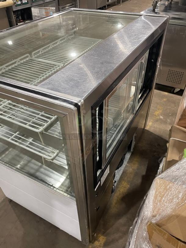 Leader late model stainless steel refrigerated bakery display case with straight glass and poly-coated wire racks.