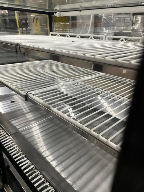 Leader commercial stainless steel refrigerated bakery display case with straight glass and poly-coated wire racks, in excellent condition.
