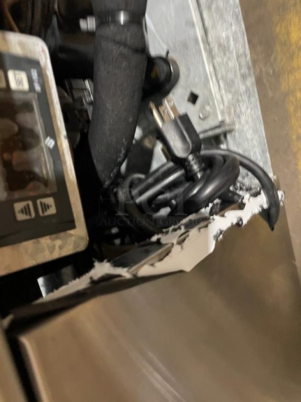 Leader commercial stainless steel refrigerated display case with straight glass and poly coated wire racks, showing exposed wiring and plug.