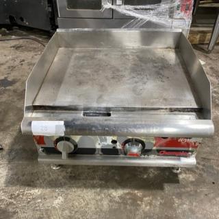 APW Wyott Champion Cook Series commercial stainless steel flat griddle, natural gas powered, with back and side splash, on legs.