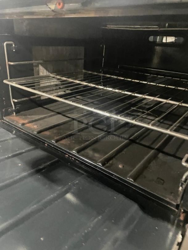 Wolf commercial stainless steel natural gas 4-burner range and oven combo with wire rack and backsplash. Clean condition.