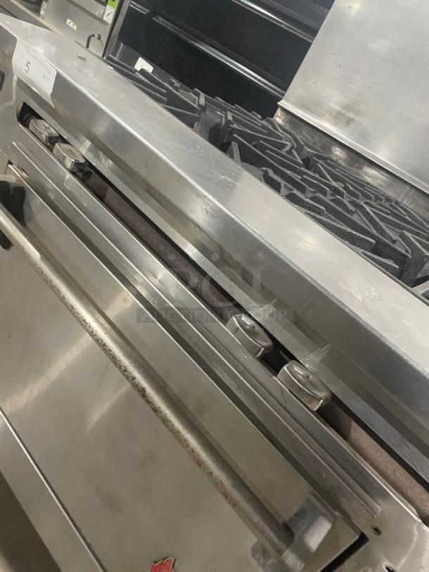 Wolf commercial stainless steel 4-burner natural gas range/oven combo with backsplash and wire oven rack; previously working.