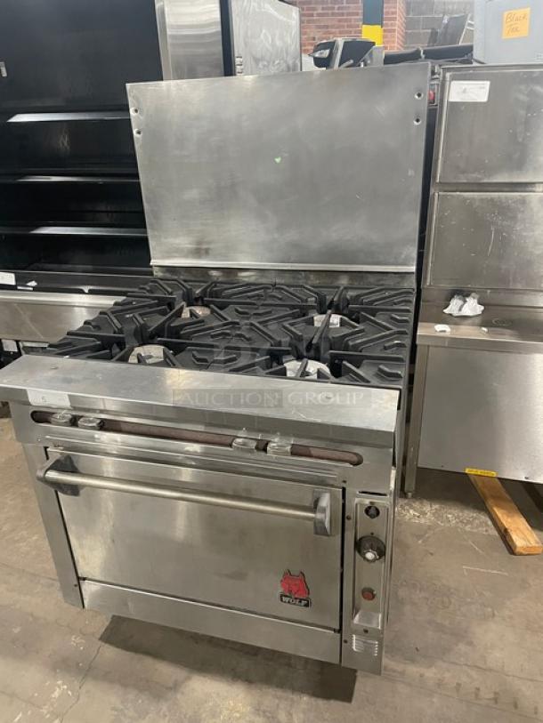 Wolf commercial stainless steel 4-burner range/oven combo, natural gas, with back splash and wire oven rack. Excellent condition.