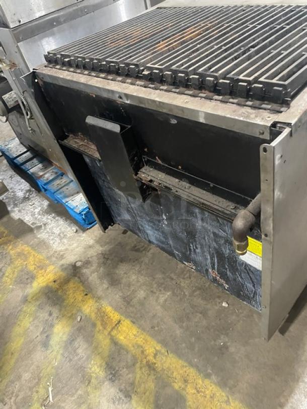Commercial stainless steel natural gas char broiler range/oven combo with wired oven rack. Signs of wear.