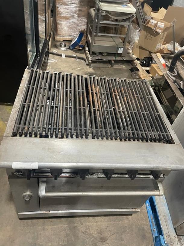 Commercial stainless steel natural gas char broiler range/oven combo with wired oven rack, industrial setting.