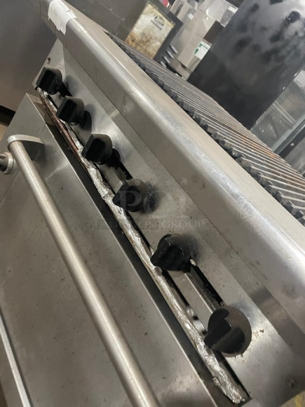 Commercial stainless steel char broiler range/oven combo with wired oven rack. Features gas knobs, grill top, and sturdy build.