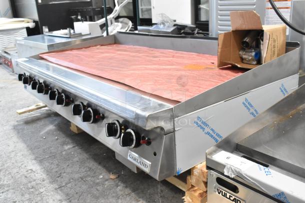 Brand new Garland stainless steel commercial countertop natural gas griddle, scratch and dent, multiple control knobs visible.