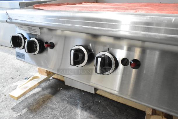 Brand new Garland stainless steel natural gas flat top griddle, scratch and dent, with operational knobs visible.