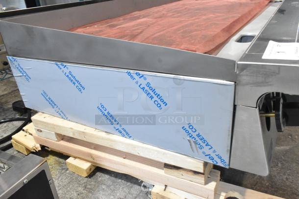 Brand new Garland stainless steel countertop natural gas flat top griddle, minor scratches, protective film visible.