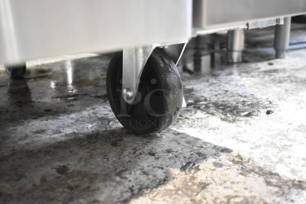 Alt text: Close-up of caster wheel on 2023 Migali C-CB72-76-HC stainless steel chef base, showing sturdy condition.
