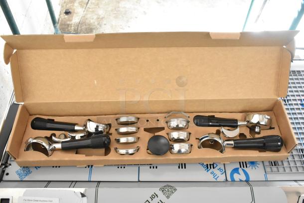 Box of components for Nuova Simonelli 238AUWV3, including 4 portafilters, in original packaging.