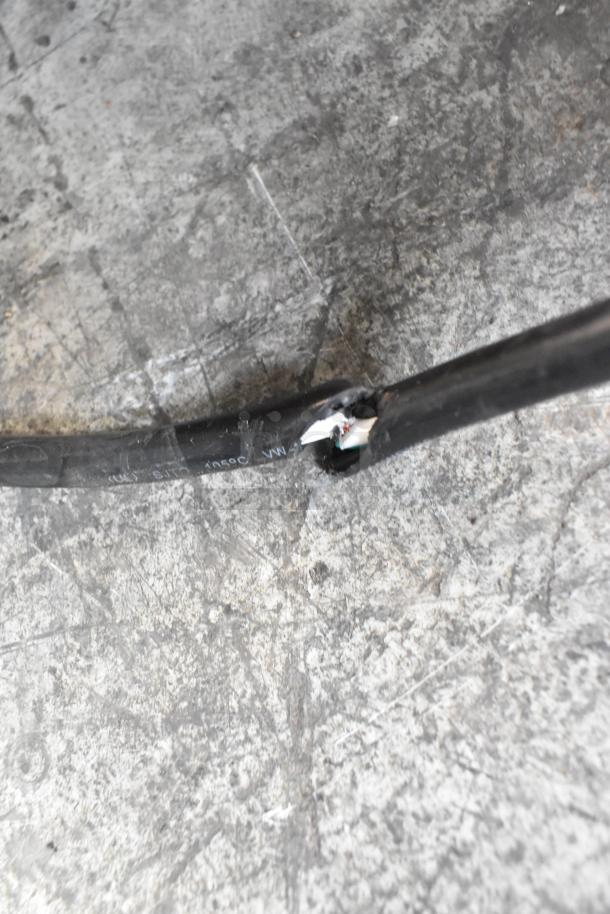 Damaged power cord of Avantco 177EG30N electric griddle, highlighting exposed wires on concrete surface.