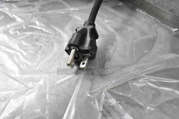 Alt text: Avantco 177EG30N electric griddle plug on stainless steel surface, wrapped in protective plastic.