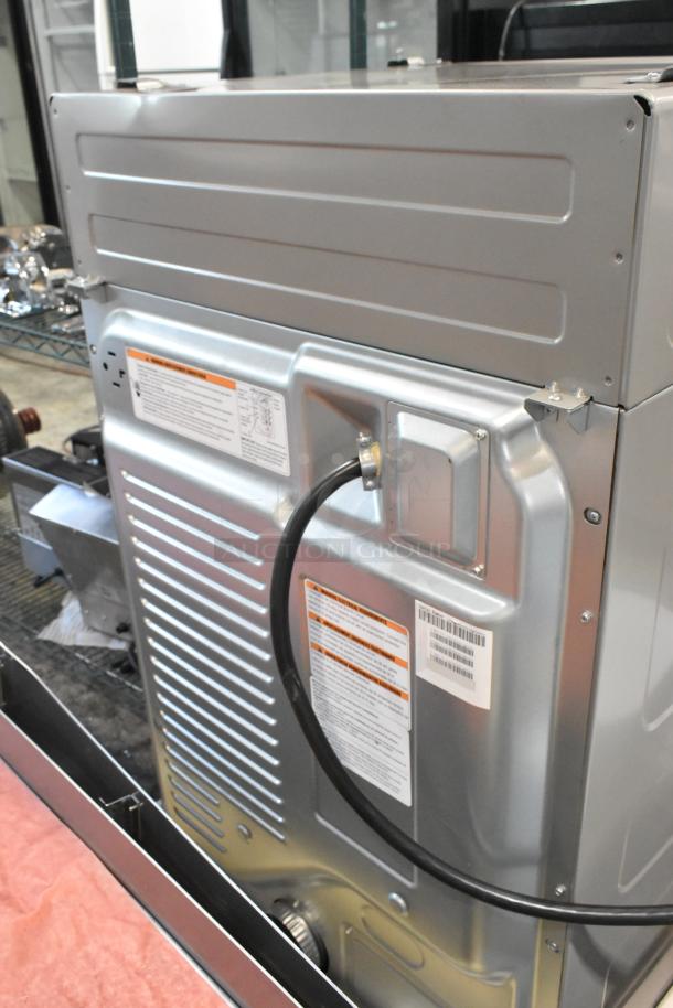 Crossover DLHS0817EC2 7 cu. ft. electric dryer, new with minor dents, 27" front load, 120/208-240 volts, tags visible.