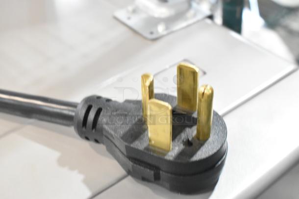 Close-up of the power plug on a Crossover DLHS0817EC2 commercial dryer, highlighting its three-prong design.