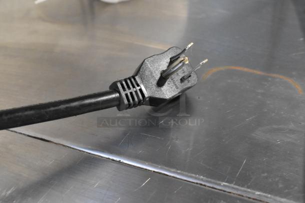 Close-up of a power plug for the Central 69K-032HC stainless steel commercial 2-door reach-in cooler, 115 volts, 1 phase.