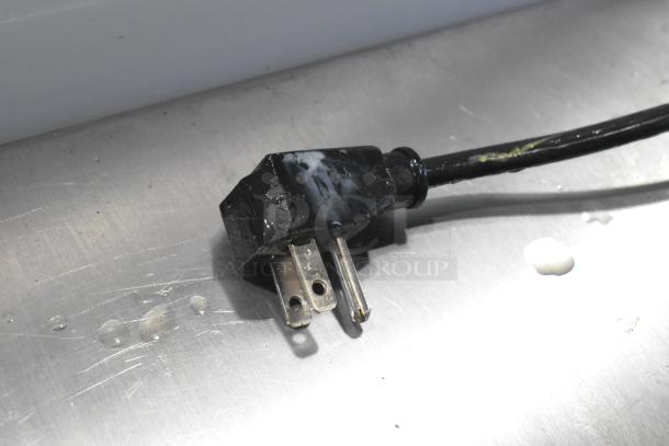Power plug of Excellence HL-11HC commercial freezer. Plug is standard 115 volts, one phase. Slight wear visible.
