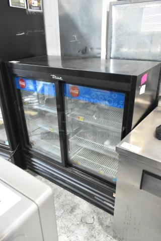2019 True GDM-41SL-48-HC-LD commercial 2-door cooler with poly-coated racks. Black metal, visible Coca-Cola branding, well-maintained.