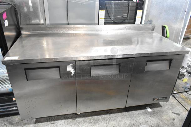 True TWT-72 stainless steel commercial worktop cooler with backsplash, on casters. Features 3 doors, 115 volts, 1 phase. Some surface wear.