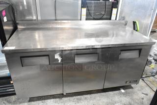 True TWT-72 stainless steel commercial worktop cooler with backsplash, on casters. Features 3 doors, 115 volts, 1 phase. Some surface wear.