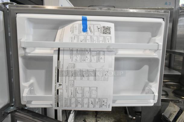 2025 Whirlpool 21MSTFATR6 stainless steel cooler with freezer, open door showing white interior and manual. 115 volts, 1 phase.