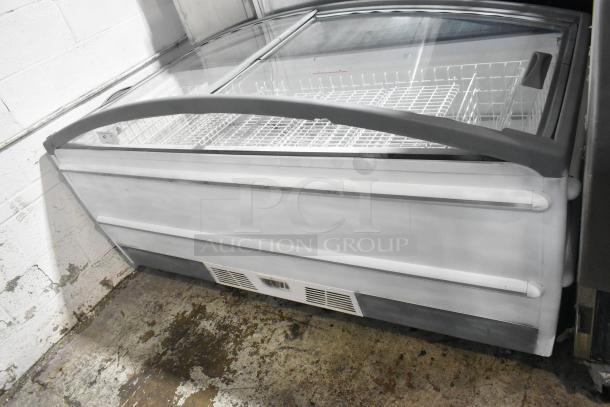 Metal commercial horizontal freezer merchandiser with clear cover, on casters. Features internal wire racks, white exterior.
