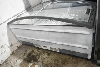 Metal commercial horizontal freezer merchandiser with clear cover, on casters. Features internal wire racks, white exterior.