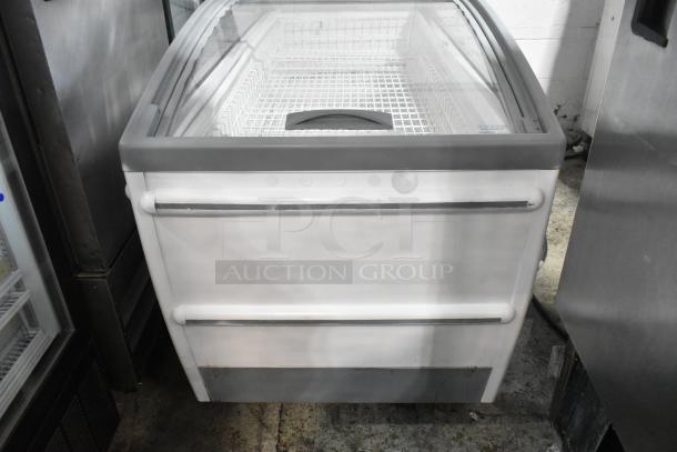 Metal commercial horizontal freezer merchandiser with a clear cover, on casters, features interior shelving. Suitable for retail use.