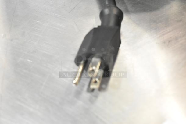 Close-up of a power plug from a Winco Spectrum ECT-300 stainless steel commercial countertop conveyor toaster oven, 120 volts.