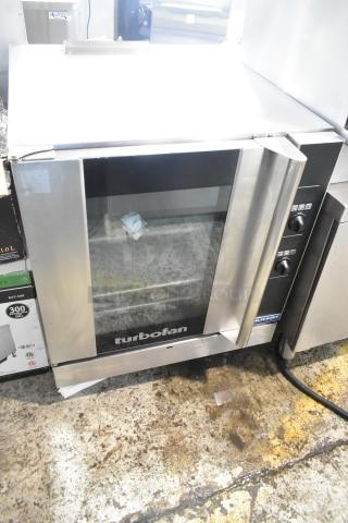 Moffat Turbofan stainless steel half-size convection oven, electric-powered, view-through door, metal racks, commercial use.